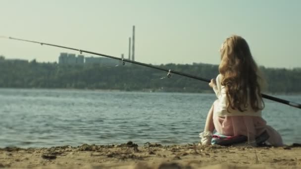 Aranyos kis lány játszik egy horgászbot egy csónak, a folyó közelében — Stock videók