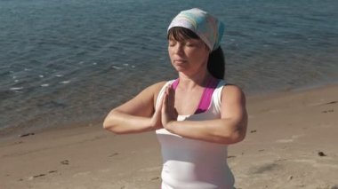 Sahilde bazı yoga yaparken eski emekli kadın