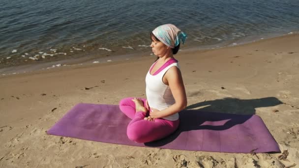 Gammel pensioneret kvinde laver noget yoga på stranden super slow motion – Stock-video
