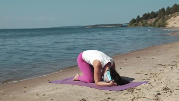 Gammal pensionerad kvinna göra några yoga på stranden — Stockvideo