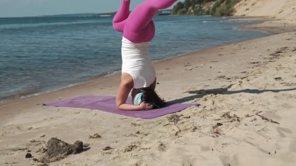 Vecchia donna in pensione facendo un po 'di yoga sulla spiaggia — Video Stock