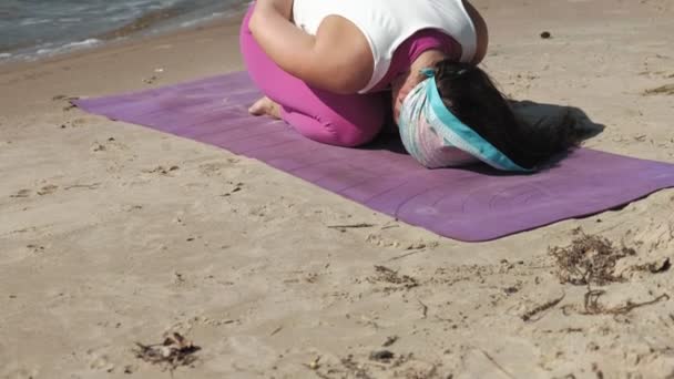Gammal pensionerad kvinna göra några yoga på stranden — Stockvideo