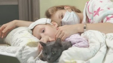 Ateşli çocuk anne ve kedi ile yatakta yalan ateşli kız hasta