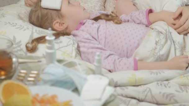 Niña enferma con fiebre. Niño con fiebre: una mujer que cuida de un niño y que está medicando — Vídeos de Stock