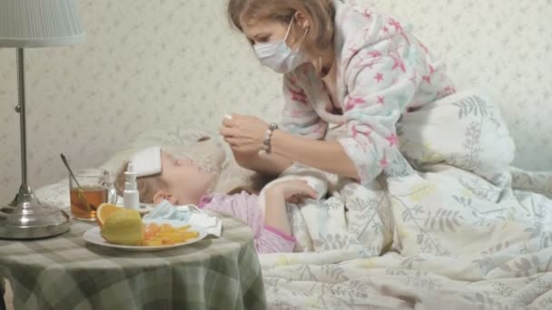 Niña enferma con fiebre. Niño con fiebre: una mujer que cuida de un niño y que está medicando — Vídeo de stock