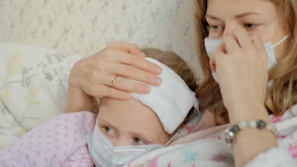 Больная девушка с температурой. Ребенок с лихорадкой лежит в постели с матерью, ест фрукты и с помощью ноутбука . — стоковое видео