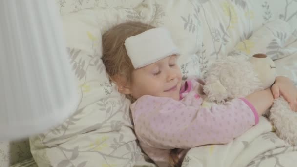 Sick girl with fever. Child with fever: a woman caring for a child and medicating — Stock Video