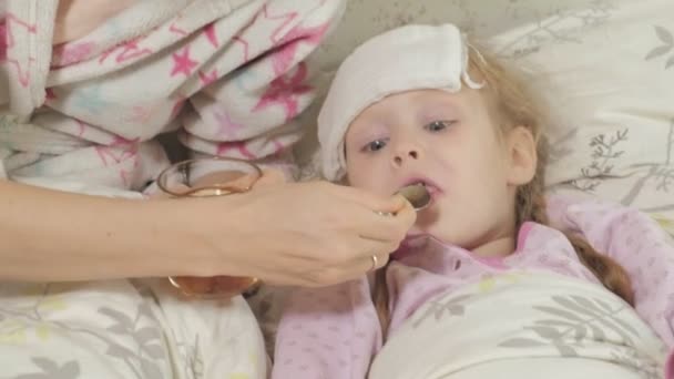 Хвора дівчина з гарячкою. Дитина з гарячкою: жінка піклується про дитину і лікує — стокове відео