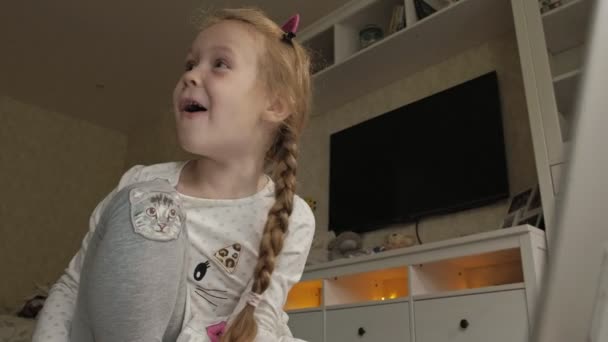 Счастливая маленькая девочка дома работает с ноутбуком — стоковое видео