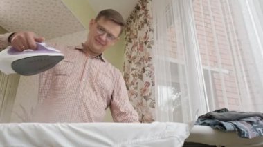 Bir adam onun evinde Ütü masası üzerinde gömleğini vuruş