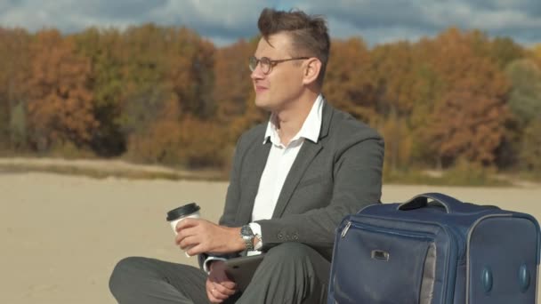 Üzletember dolgozik, pihentető a strandon, egy laptop bőrönddel — Stock videók