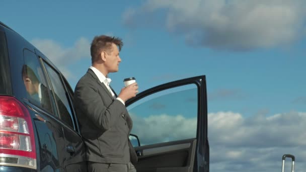 Zakenman met een koffer van de laptop werken ontspannen op het strand in de buurt van zijn auto. — Stockvideo