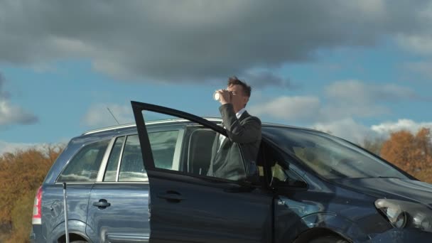 Podnikatel s přenosný kufr, práci, relaxaci na pláži nedaleko jeho auto. — Stock video