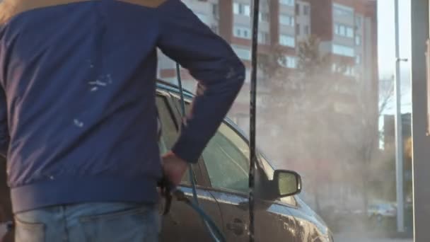 Ένας άνθρωπος πλύσιμο του αυτοκινήτου υπό υψηλή πίεση νερού σε εξωτερικούς χώρους — Αρχείο Βίντεο