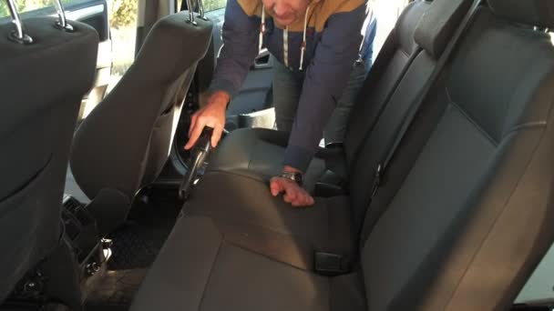 Handyman vacuuming car back seat with vacuum cleaner — Stock Video