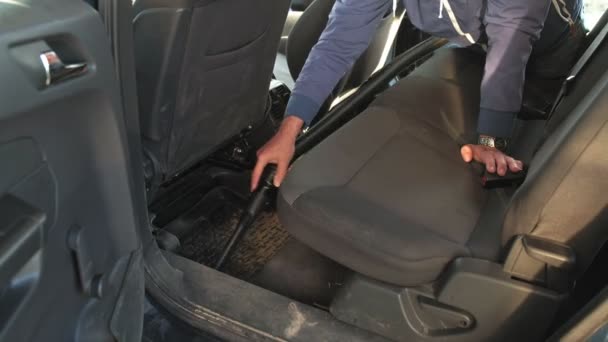 Klusjesman stofzuigen achterbank van de auto met stofzuiger — Stockvideo