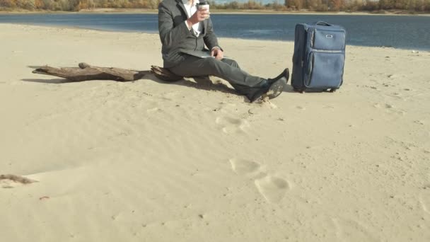 Επιχειρηματίας με μια βαλίτσα lap-top εργασίας χαλάρωση στην παραλία — Αρχείο Βίντεο