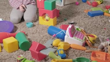 Güzel gülüyor küçük çocuk, okul öncesi sarışın, oda katta oturan renkli oyuncaklar ile oynama