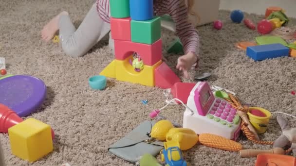 Güzel gülüyor küçük çocuk, okul öncesi sarışın, oda katta oturan renkli oyuncaklar ile oynama — Stok video