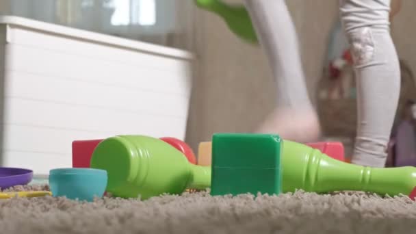 Милая смеющаяся маленькая девочка, блондинка в детском саду, играющая с красочными игрушками в белой коробке, сидящая на полу в комнате — стоковое видео
