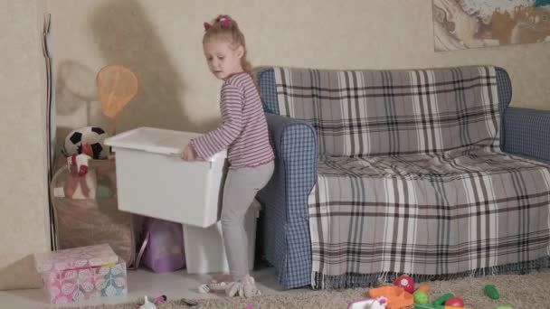 Härlig skrattar lite kid, förskola blond, leker med färgglada leksaker, sitter på golvet i rummet — Stockvideo