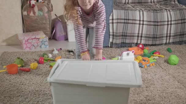 Precioso niño riendo, rubia preescolar, jugando con juguetes coloridos, sentado en el suelo en la habitación — Vídeos de Stock