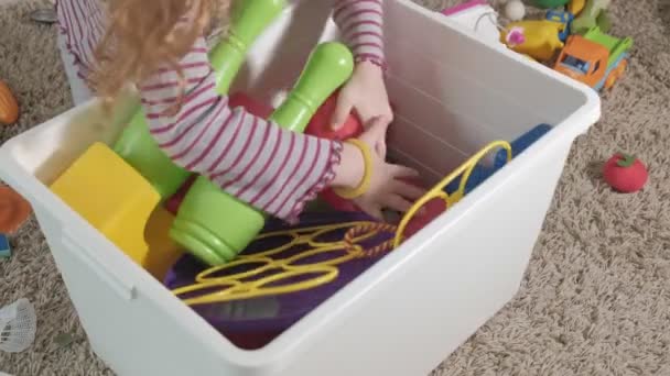 Precioso niño riendo, rubia preescolar, jugando con juguetes coloridos, sentado en el suelo en la habitación — Vídeo de stock
