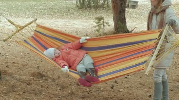 Adorabile bambino seduto in amaca sotto gli alberi — Video Stock