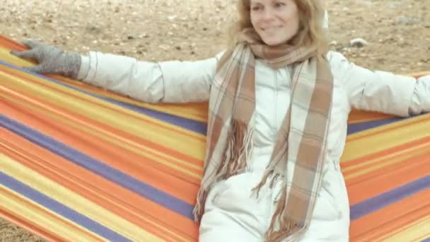 Charming woman sitting in a hammock under the trees — Stock Video