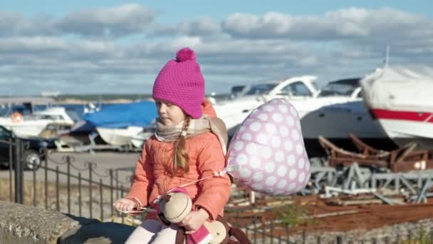 Menina com um balão senta-se em um porto fluvial viagens — Vídeo de Stock