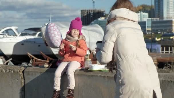 Uma mulher com uma menina, uma mãe com uma filha, em um porto fluvial, uma mulher tira fotos de uma criança — Vídeo de Stock