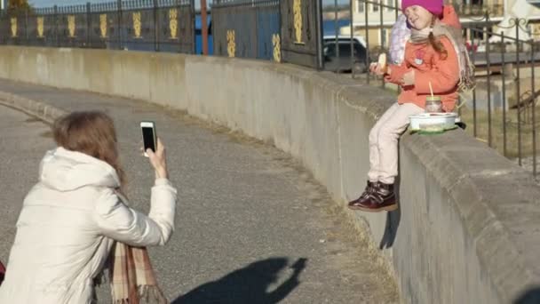 Una mujer con una niña, una madre con una hija, en un puerto fluvial, una mujer toma fotos de un niño, un niño sonríe — Vídeo de stock