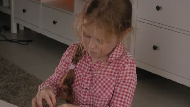 Malá holčička se sestaví z návrháře krychle. Radost ze hry — Stock video