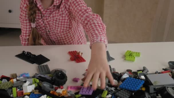 La niña se construye a partir de los cubos de diseño. La alegría de los juegos — Vídeo de stock