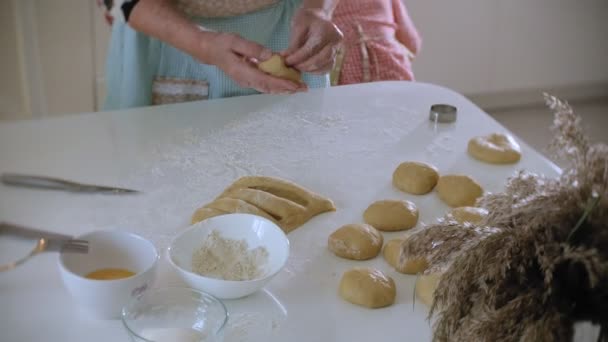 Kleines Mädchen und ihre Großmutter backen in der Küche Kekse aus Teig — Stockvideo