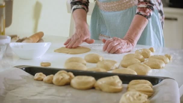 Счастливая пожилая женщина катит печенье тесто дома на кухне — стоковое видео