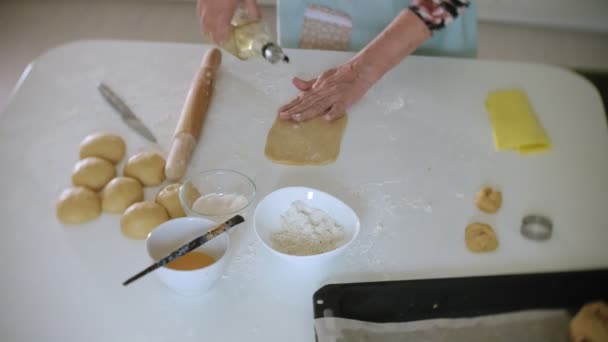 Glückliche Seniorin rollt Plätzchenteig zu Hause in der Küche — Stockvideo