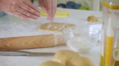 Mutlu kadın kıdemli bisküvi hamur evde mutfakta haddeleme