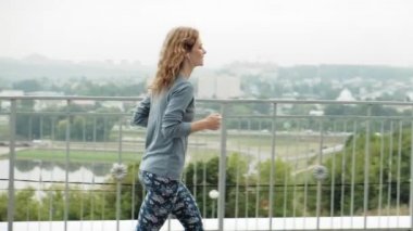 Bir yerleşim bölgesinde süper ağır çekim çalıştırmak bir egzersiz olan genç fitness kadın