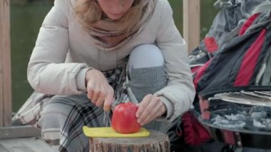 Nehir kıyısında bir sırt çantası ile yakın bir köprü üzerinde sıcak giysiler kadın turist Sita sebze, ızgara, piknik, aktif dinlenme, sağlıklı bir yaşam tarzı yemek hazırlanıyor. Seyahat kavramı