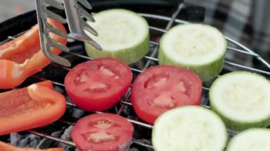 Nehir kıyısında bir sırt çantası ile yakın bir köprü üzerinde sıcak giysiler içinde bir kadın turist hazırlar ızgara sebze, kabak, tatlı biber, domates, piknik, açık hava etkinlikleri, sağlıklı bir yaşam tarzı. Seyahat