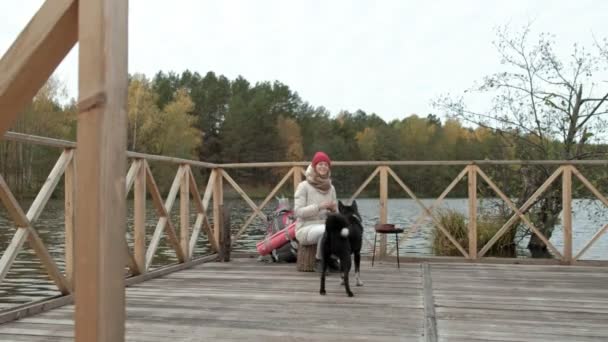 Женщина Туристка Сидит Мосту Реки Кормит Собаку Активный Отдых Свежем — стоковое видео