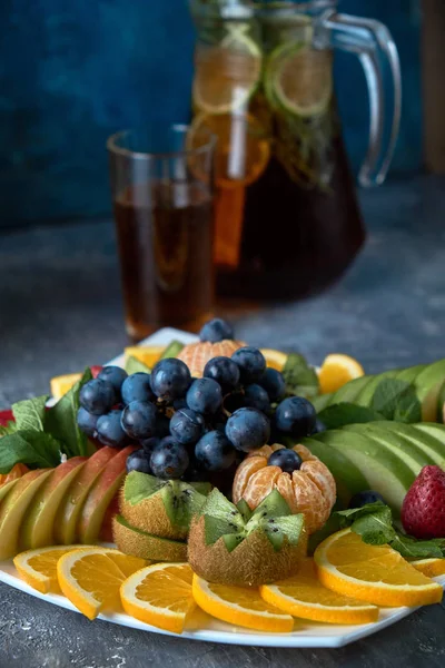 fruit plate. Glass bank of lemonade with sliced citrus fruits on a buffet table