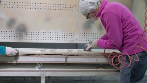 Женщина, рабочий производит эффект старения дверей. производство межкомнатных дверей из дерева — стоковое видео