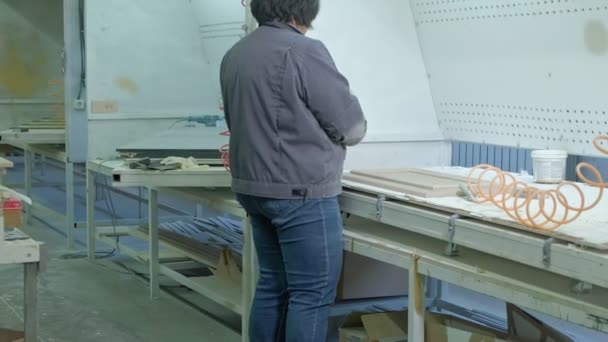 Uma mulher, uma trabalhadora, cuspiu a superfície da porta. produção de portas interiores de madeira — Vídeo de Stock