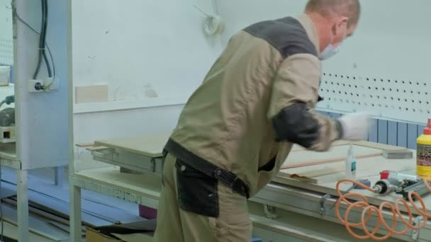 Trabajador masculino pegando espacios en blanco de madera para una puerta. producción de puertas interiores de madera — Vídeos de Stock