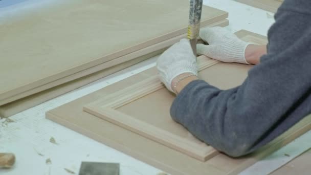 Работник-мужчина приклеивает деревянные заготовки к двери. производство внутренних дверей из дерева — стоковое видео