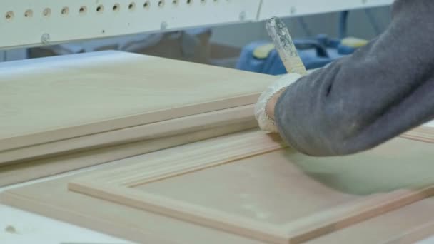 Mannelijke werknemer lijmen van houten blanks voor een deur. productie van binnendeuren van hout — Stockvideo