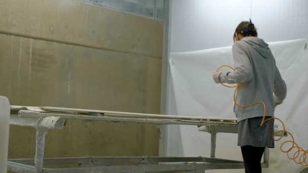 Une femme, une ouvrière, peint un blanc en bois pour faire une porte. Le processus de fabrication de portes en bois. production de portes intérieures en bois — Video