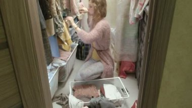 Güzel bir kız gülümsüyor, sıralar ve giysileri içinde sepetleri soyunma odasina kıvrımlar. amacıyla bir şeyler koyar